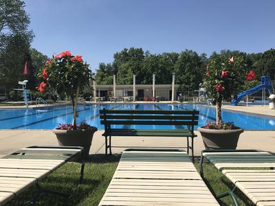lounge chairs and benches in front of Minerva Park Pool 